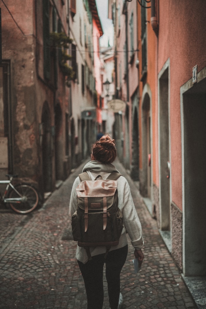 Traveller walking through a European laneway with a backpack