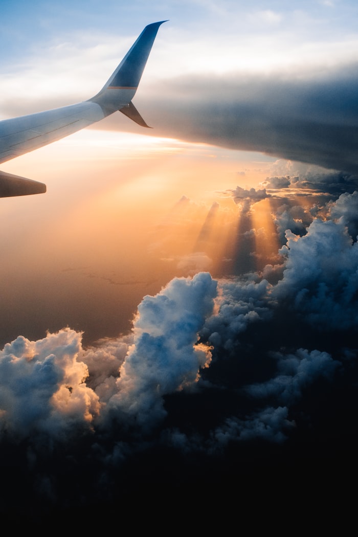 View of an aircraft wing above the clouds at sunset
